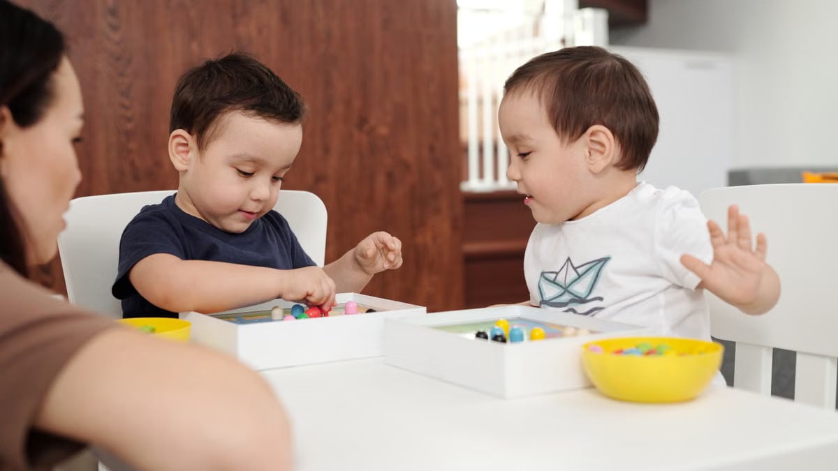 Two children playing with toys under the supervision of their mother in a cozy home setting.